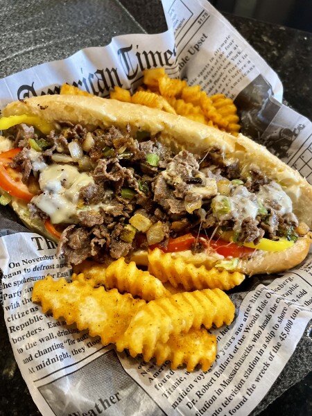 A loaded cheesesteak with waffle fries