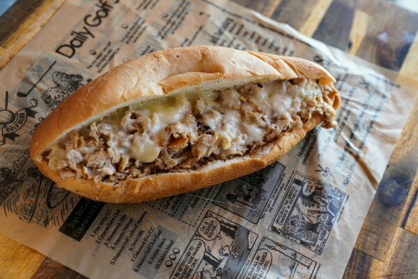 A chicken cheesesteak on newsprint
