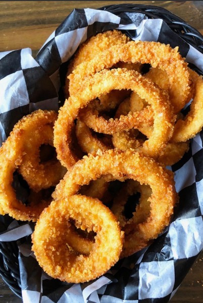A basket of hand-breaded onion rings